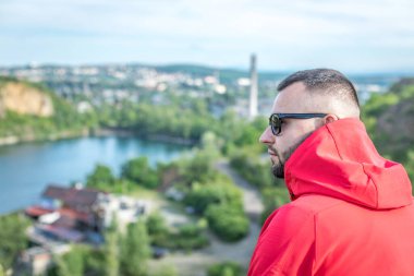 Quarry Gölü 'nde genç ve çekici sakallı bir adam manzaranın tadını çıkarıyor. Hafta sonu konseptinde kamp gezisi.