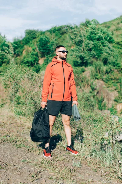 Sonbaharda ya da Quarry Gölü 'ndeki bahar manzaralı kırmızı ceketli yakışıklı adam fotoğrafı..