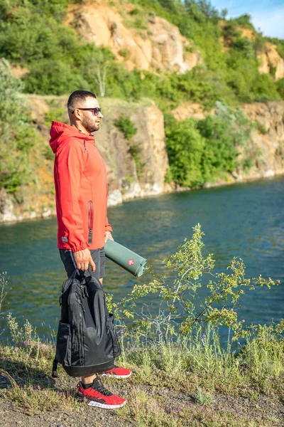 Sonbaharda ya da Quarry Gölü 'ndeki bahar manzaralı kırmızı ceketli yakışıklı adam fotoğrafı..