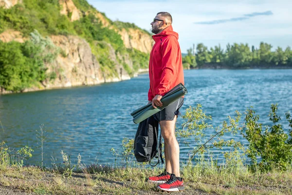 Sonbaharda ya da Quarry Gölü 'ndeki bahar manzaralı kırmızı ceketli yakışıklı adam fotoğrafı..