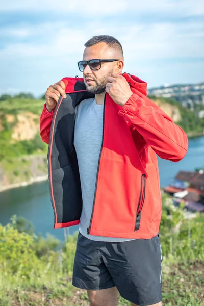 Quarry Gölü 'nde genç ve çekici sakallı bir adam manzaranın tadını çıkarıyor. Hafta sonu konseptinde kamp gezisi.