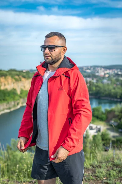 Quarry Gölü 'nde genç ve çekici sakallı bir adam manzaranın tadını çıkarıyor. Hafta sonu konseptinde kamp gezisi.