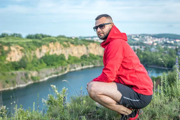 Güneşli bahar gününde Quarry Gölü 'nde dikilen mutlu sakallı adam..