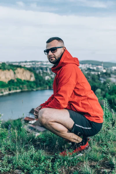 Güneşli bahar gününde Quarry Gölü 'nde dikilen mutlu sakallı adam..