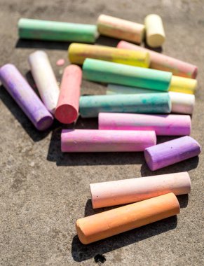 Beton bir arka planda çeşitli renklerde renkli tebeşirler.