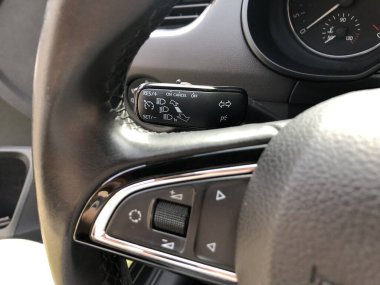 Hızlı kontrol için birden fazla düğmesi olan modern siyah direksiyon, arabaya yakın çekim. Siyah salonlu arabanın iç görünümü