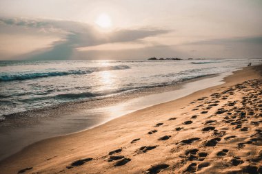 Günbatımında Sri Lanka 'da popüler turistik mekan Mirissa plajı; gün batımında sakin renklerde gün batımı fotoğrafı; güney Sri Lanka' da kıyı manzarası.