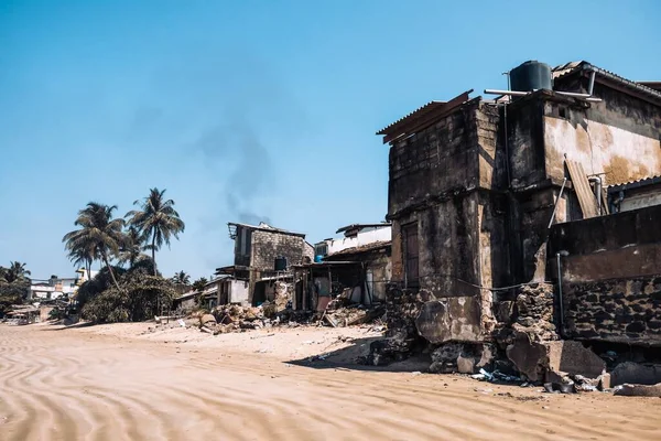 Fire damaged buildings in the middle of popular touristic beach in Sri Lanka. Polluted and damaged place near surfing beach.