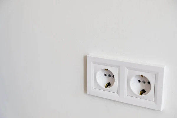 白い壁に白いヨーロッパの高電圧220Wソケットが2つあり 空白のコピースペースがあります 典型的な近代的な家庭のインテリア 改装や家の改造に不可欠な 電力の節約 — ストック写真