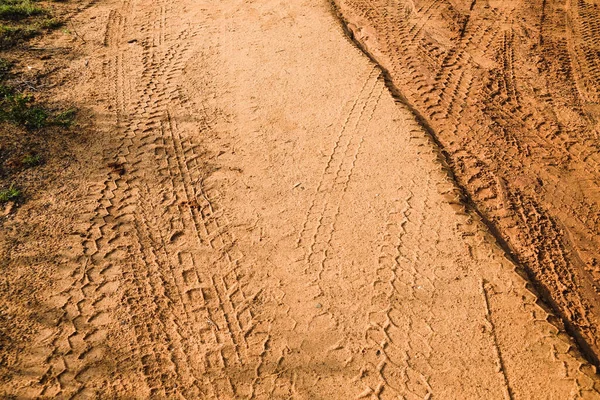 Tire tracks left after a jeep safari on a muddy road. A brown texture with a dirty sandy surface from the Udawalawe National Park, Sri Lanka.