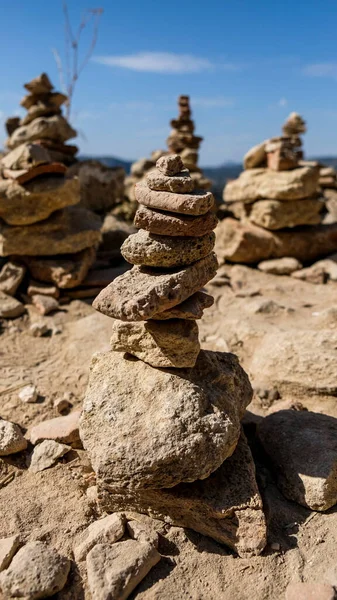 Vertical piles of rocks stacked near the famous bridge in Ronda. Close up view in the midday with bright blue sky in the background.