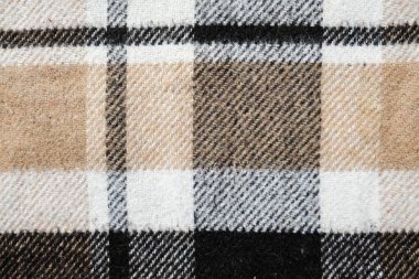 Kahverengi ekose battaniye. Tam boyutlu arkaplan dokusunun görüntüsünü kapat. Kumaş parçası. İzolasyonda çalışırken ya da evde çalışırken örtbas etmek için sıcak malzemeler ısıtıyorum. Mevsimlik rahatlık.