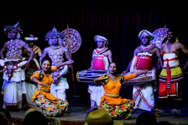 Kandy / Sri Lanka - Şubat 2020: Sri Lankalı performansı. Geleneksel parlak elbiseli yerel sanatçılar sahnede dans ediyorlar. Kadınlar çalıyor, erkekler davul çalıyor..