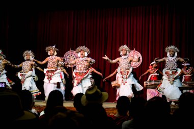 Kandy / Sri Lanka - Şubat 2020: Sri Lankalı performansı. Geleneksel parlak elbiseli yerel sanatçılar sahnede dans ediyorlar. Davul çalıp Kandy 'de çalan kostümlü bir sürü adam var..