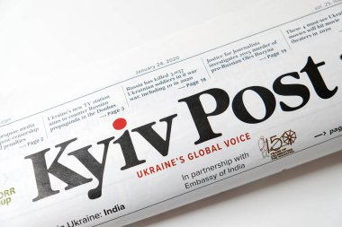 Lviv / Ukrayna - Mart 2020: Katlanmış Ukrayna gazetesi Kyiv Post 'un beyaz bir masanın ön sayfasına bakın. Tecrit sırasında evden okumak ve çalışmak. Ukrayna 'da yerel haberler.
