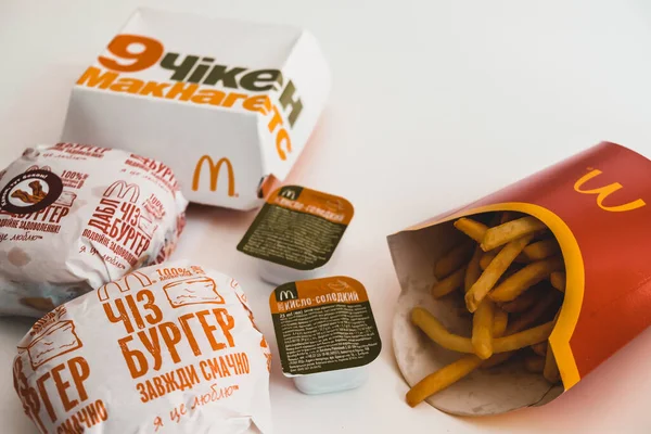 Lviv / Ukrayna - Nisan 2020: Coronavirus salgını sırasında evde sağlıksız yemek. Paket McDonalds yemeği masada. Ukrayna usulü tavuk Mcnugget, çizburger ve patates kızartması..