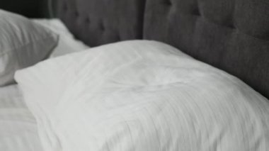 Coronavirus salgını sırasında maskeli genç beyaz bir kız yatağa giriyor. Hastalığı önlemek ve salgında sağlıklı kalmak için karantinada uyurken yüz maskesi takmak. Yatak odasındaki kadın, evde kal. 