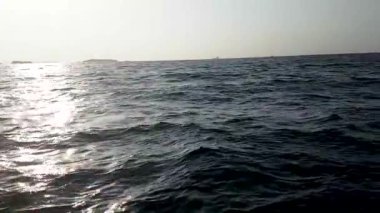 Su yüzeyinde dalgalı deniz ve güneş ışığı. Hint Okyanusu 'nda gün batımını izlemek için tekne gezisi. Büyük dalgalar, turist hız teknesinin manzarası..