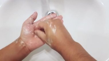 Birisi ellerini sabun önleme kovid-19 ile yıkıyor.