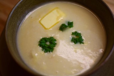 Kremalı ve tereyağlı kremalı karnabahar çorbası dekoratif maydanoz yapraklarıyla süslenir. Modern Norveç yemekleri.