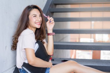 Genç öğrenci erkek oturup kitap Kampüs alanında tutarak merdivenlerde