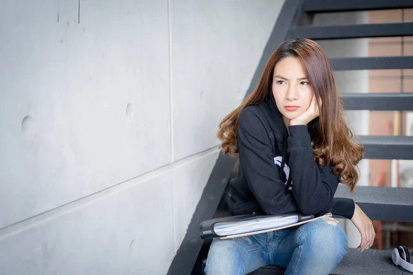 Genç öğrenci erkek kesinlikle merdiven ile belgili tanımlık ağıl ve kopya-kampüs alanı kitapta oturmak