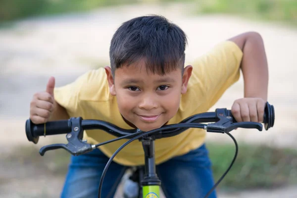 Asiático niño paseo bicicleta en la naturaleza Imagen de archivo