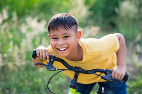 Asiático niño paseo bicicleta en la naturaleza Imágenes de stock libres de derechos