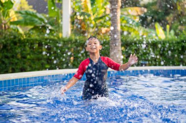 Yaz aylarında yüzme havuzunda yüzen mutlu asyalı çocuk çocuk 