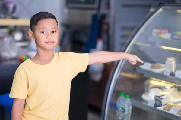 Asiático menino esperando na padaria loja e escolher padaria que oi — Fotografia de Stock
