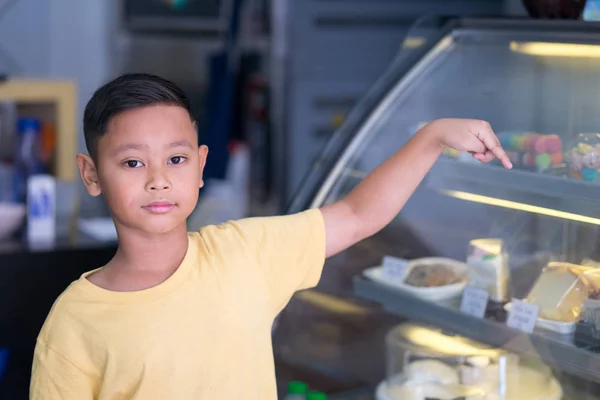 Asiático menino esperando na padaria loja e escolher padaria que oi — Fotografia de Stock