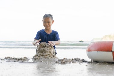 Çocuk çocuklar sahilde mutlu bir şekilde deniz oynuyorlar..