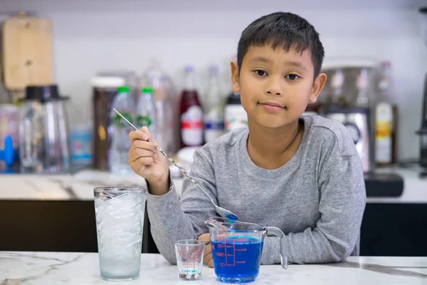 Kind Junge macht Mischung Wasser blau hawaii — Stockfoto