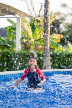 Yaz aylarında yüzme havuzunda yüzen mutlu asyalı çocuk çocuk 