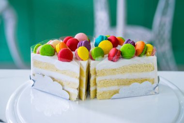 Üzerine makarna ile süslenmiş kremalı pasta, tahta bir tabağa yerleştirilir