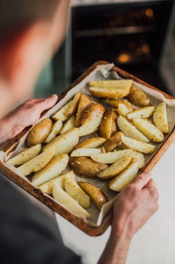 Beyaz adam patates pişiriyor. Geleneksel patates tarifi. Ev yapımı ucuz ve lezzetli yemekler yapmak kolay. Yaşam tarzı günlüğü.