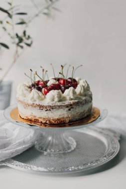 Lezzetli ve üzerinde çiğ kiraz ve krem şantili ev yapımı kek. Güzel yemek tasarımı. Mevsimlik doğum günü pastası. Yemek pişirme yaşam tarzı sınıfı veya blog yazarı kavramı. 