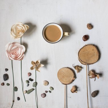 Geri dönüşümlü ve doğal elementler olan origami kağıt gülleri, çakıl taşları, ahşap dekorlar, koniler, fındıklar ve bir kahve fincanı gibi yaratıcı düz düzlükler. Günlük durum resmi veya tatil kartı için en küçük üst görünüm.