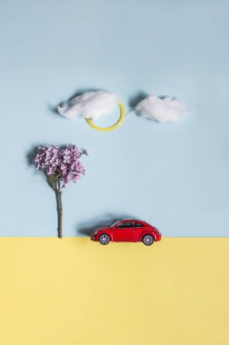 BUCHARest, RO - 16 Nisan 2019. Yaratıcı peyzaj, leylak çiçeğinden elde edilen ağaçla, bulut şeklinde pamuk ve renkli pastel arka planda kırmızı oyuncak arabalarla oluşturulmuştur. Asgari düzeyde. Düz yatıyordu