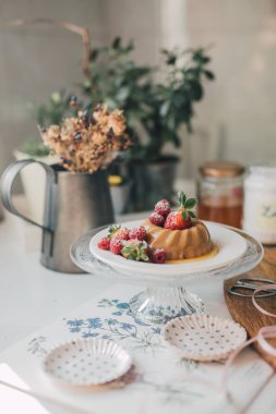 Geleneksel İtalyan tatlı panna cotta krema, hindistan cevizi şekeri ve çilekli vanilyalı ve ahududu soslu. Klasik dekore edilmiş mutfak masasında gurme yemeği. Günlük biçimi, seçici odak 
