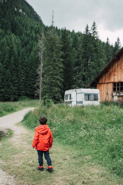 Maceracı çocuk dağ yamacının ormanlarında yürürken eğleniyor. Çocuklu aileler için eğlenceli açık hava aktiviteleri. Çocukluk yıllarında doğayı kucaklamak. Aktif çocuk yaşam tarzı. 