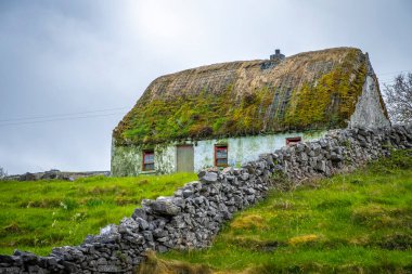 Inishmore, Aran Adası, İrlanda 'nın çatısında sazlıklar olan eski kulübeler.
