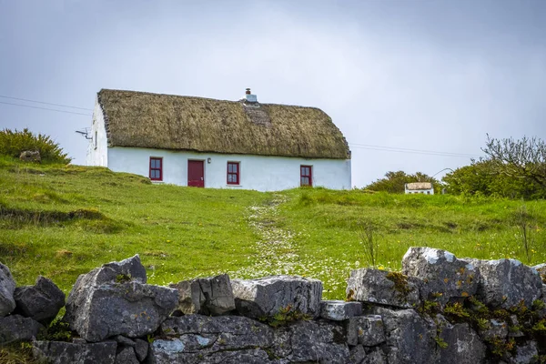 Inishmore, Aran Adası, İrlanda 'nın çatısında sazlıklar olan eski kulübeler.