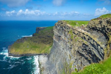 Moher, Co Clare, İrlanda 'nın muhteşem uçurumlarında yürüyorum.