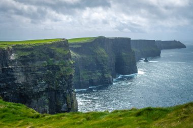 Moher, Co Clare, İrlanda 'nın muhteşem uçurumlarında yürüyorum.