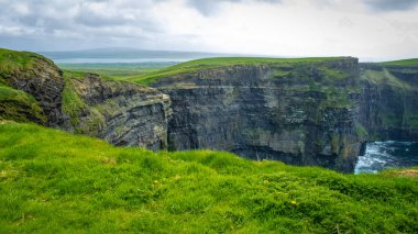 Moher, Co Clare, İrlanda 'nın muhteşem uçurumlarında yürüyorum.