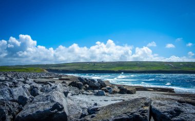 Doolin sahilinde dalgalar Moher, County Clare, İrlanda 'nın muhteşem uçurumlarına bakıyor.
