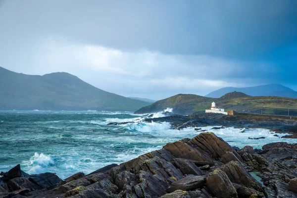 Cromwell Point Lighthouse on stone ocean coast in Ireland