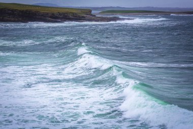 Ocean waves breaking on stone coast in Mullaghmore peninsula in County Sligo, Ireland clipart