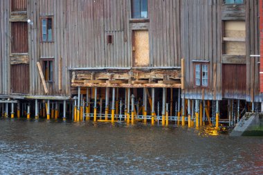 Trondheim 'daki Nidelva nehrindeki kereste yığınları üzerindeki ahşap evler.